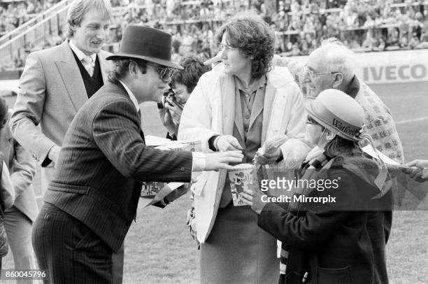 Pop star and Watford FC Chairman, Elton John, handing out Easter eggs to fans. Watford v Southampton football match, 6th April 1985.