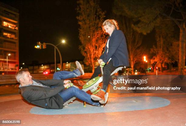 mature couple playing on seesaw - paul mansfield photography stock-fotos und bilder