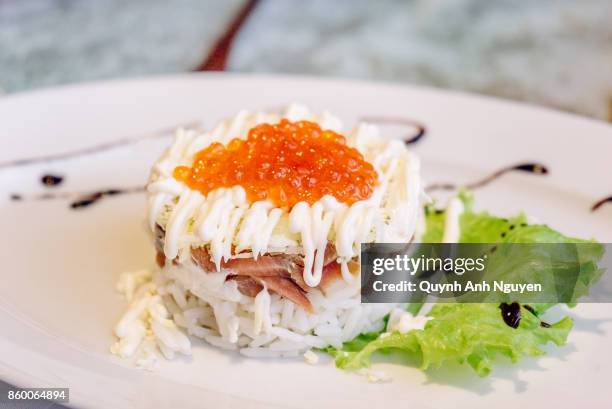 russian food: a rice and fish salad with red caviar - ikura stock pictures, royalty-free photos & images