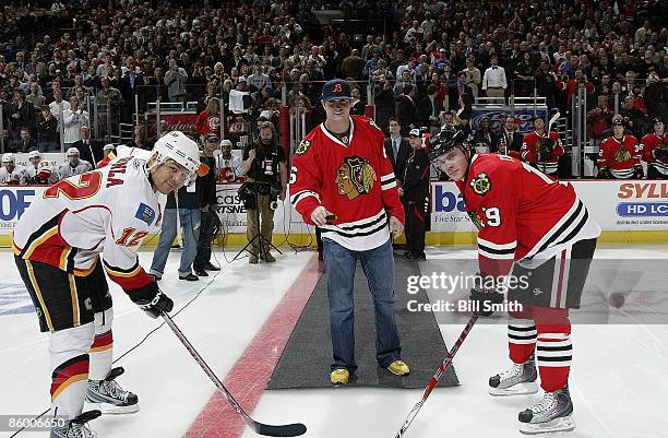 Jay Cutler of the Chicago Bears drops the puck with captains Jonathan Toews of the Chicago Blackhawks and Jarome Iginla of the Calgary Flames during...
