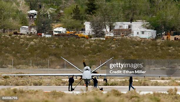 Workers look over an MQ-9 Reaper unmanned aerial system on the flight line April 16, 2009 at Creech Air Force Base in Indian Springs, Nevada. The...