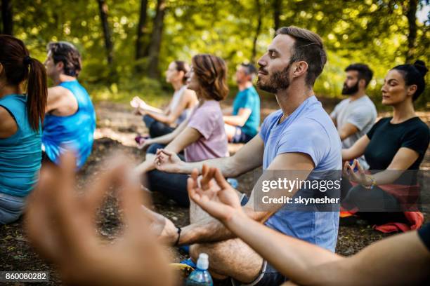 athletic people practicing yoga on a sports class in nature. - yoga outdoors stock pictures, royalty-free photos & images