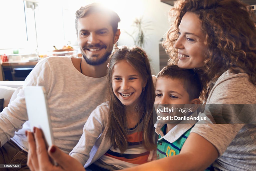 Happy young family taking a selfie at home