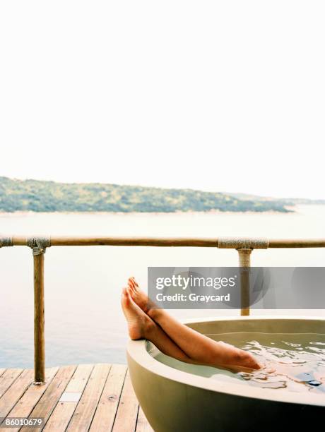 woman relaxing in a bathtub over looking a lake - bathing jetty stock pictures, royalty-free photos & images