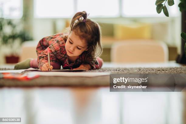 kleines mädchen mit filzstift schreiben, während sie gemütlich auf teppich zu hause. - kid with markers stock-fotos und bilder