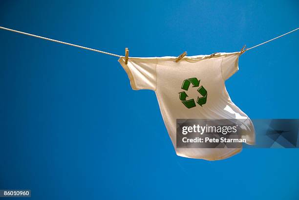 t-shirt w/ recycle symbol hanging on clothes line. - kledingstuk stockfoto's en -beelden