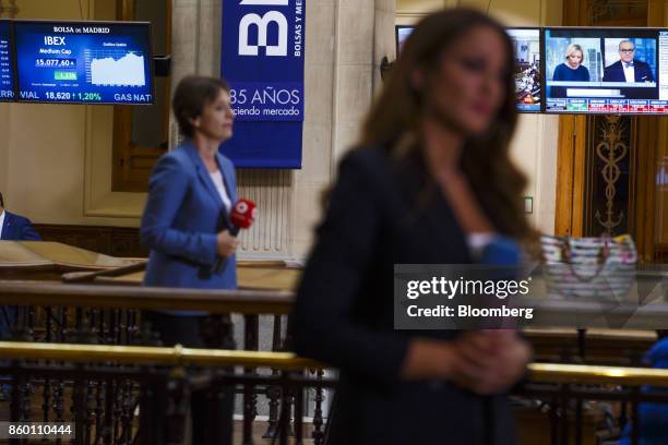 Television news reporters broadcast reports on Spanish stock prices from the Madrid Stock Exchange, also known as Bolsa de Madrid, in Madrid, Spain,...