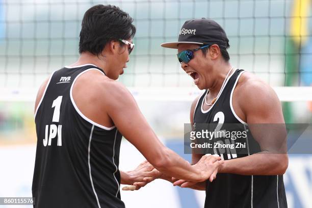 Yu Koshikawa and Yoshiumi Hasegawa of Japan celebrate during the qualification match of 2017 FIVB Beach Volleyball Qinzhou Open against Junki Hatabe...