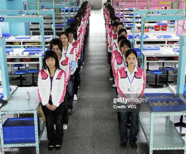 Neoglory Jewelry Company workers stand by their desks on April 16, 2009 in Yiwu of Zhejiang Province, China. The Neoglory Jewelry Company is the...
