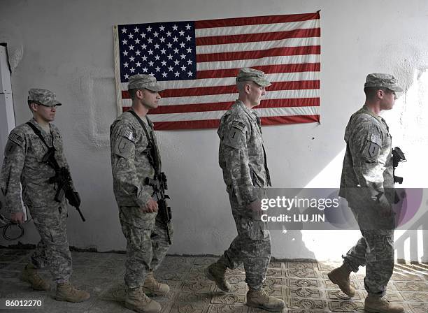 Soldiers walk in front of the US national flag during a visit by Major General Jeffrey J. Schloesser, Commanding General, 101st Airborne Division and...