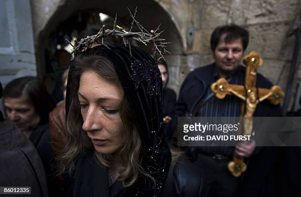 Christian Orthodox pilgrim wearing a crown of thorns enters the Church of the Holy Sepulchre during the Good Friday procession in Jerusalem's Old...
