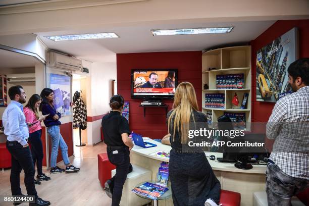 Students and employees of an education company watch the TV broadcast of US ambassador John Bass' presser, on October 11, 217 in Istanbul. President...