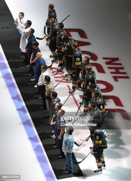 Police, fire and medical personnel line up on the ice in front of the Vegas Golden Knights before their inaugural regular-season home opener against...