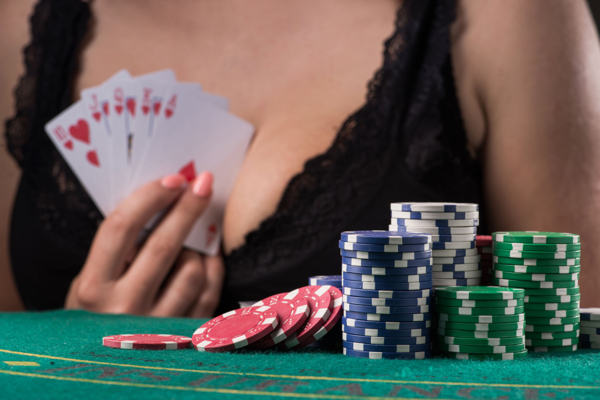 woman holding royal flush cards on dark background woman holding royal flush cards on dark background