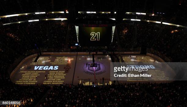 The names of the 58 people killed at the Route 91 Harvest country music festival are projected on the ice as the scoreboard counts 58 seconds of...