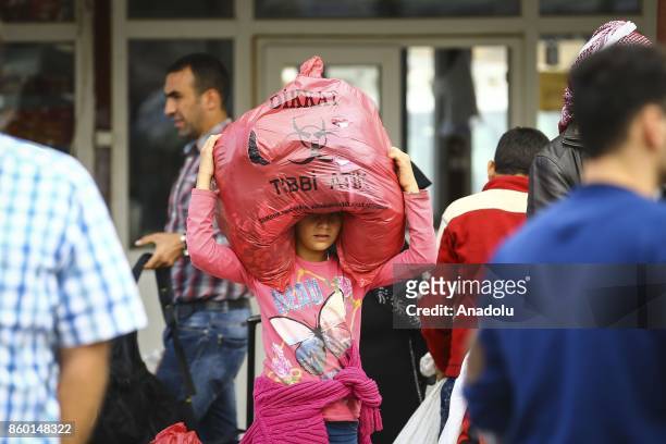 Syrian girl with her belonging is seen on International Day of the Girl Child as Syrians, who went to their hometowns for Eid al-Adha, continue to...