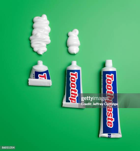 three toothpaste tubes and toothpaste - tube photos et images de collection