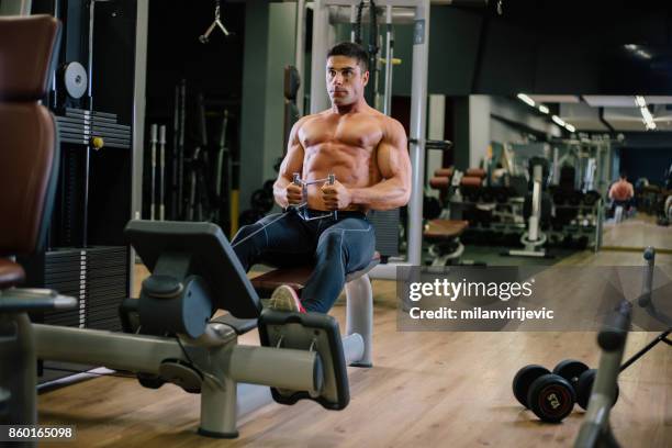 muscular fit man exercising in a gym - arab bodybuilder stock pictures, royalty-free photos & images
