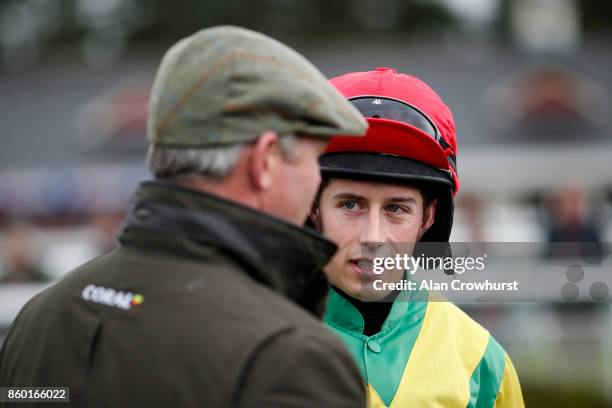 Jockey Bryan Cooper in the Ann & Alan Potts colours chats to Joe Tizzrad at Ludlow racecourse on October 11, 2017 in Ludlow, England.