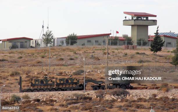 Picture taken on October 11 from the Syrian village of Atme in the northwestern province of Idlib shows Turkish military vehicles driving around a...