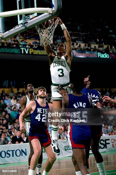 Dennis Johnson of the Boston Celtics dunks against Albert King and Mike Gminsky of the New Jersey Nets during an NBA game played in 1986 at the...