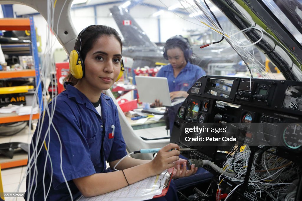Young female engineers working with helicopters