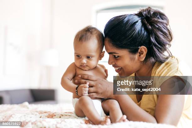 mom and baby indoor - asian and indian ethnicities imagens e fotografias de stock
