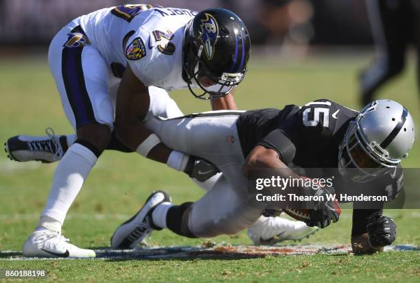 Michael Crabtree of the Oakland Raiders gets tackled by Marlon Humphrey of the Baltimore Ravens during the third quarter of their NFL football game...