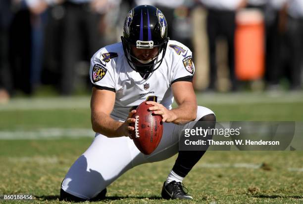 Sam Koch of the Baltimore Ravens holds the ball for a field goal attempt against the Oakland Raiders during the fourth quarter of an NFL football...