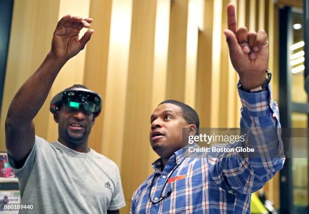 Landen Sarter, left, gets advice from Milton Irving CEO Timothy Smith on the Microsoft HoloLens holographic headset during the Network HUBweek event...