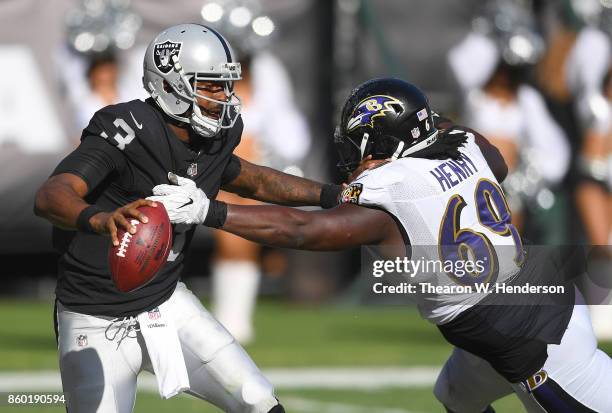 Manuel of the Oakland Raiders looks to get his pass off under pressure from Willie Henry of the Baltimore Ravens during the fourth quarter of their...