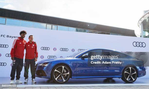 David Alaba and Rafinha of FC Bayern Muenchen pose with their car during the FC Bayern Muenchen New Car Handover at the Audi Forum on October 11,...