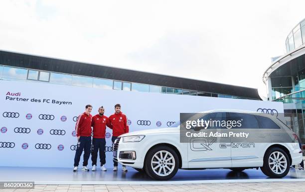 Sebastian Rudy, Arturo Vidal and Javi Martinez of FC Bayern Muenchen pose with their car during the FC Bayern Muenchen New Car Handover at the Audi...