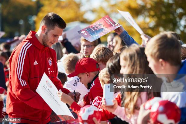Niklas Suele of Bayern Muenchen signs autographs for fans during the FC Bayern Muenchen New Car Handover at the Audi Forum on October 11, 2017 in...
