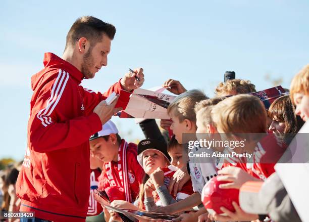 Niklas Suele of Bayern Muenchen signs autographs for fans during the FC Bayern Muenchen New Car Handover at the Audi Forum on October 11, 2017 in...