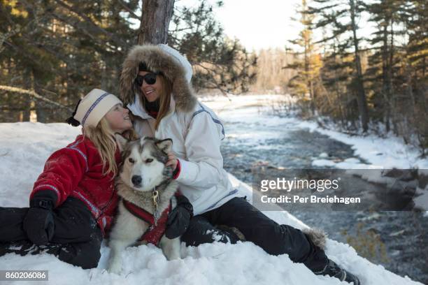 mother and daughter with sled dog - ely minnesota stock pictures, royalty-free photos & images