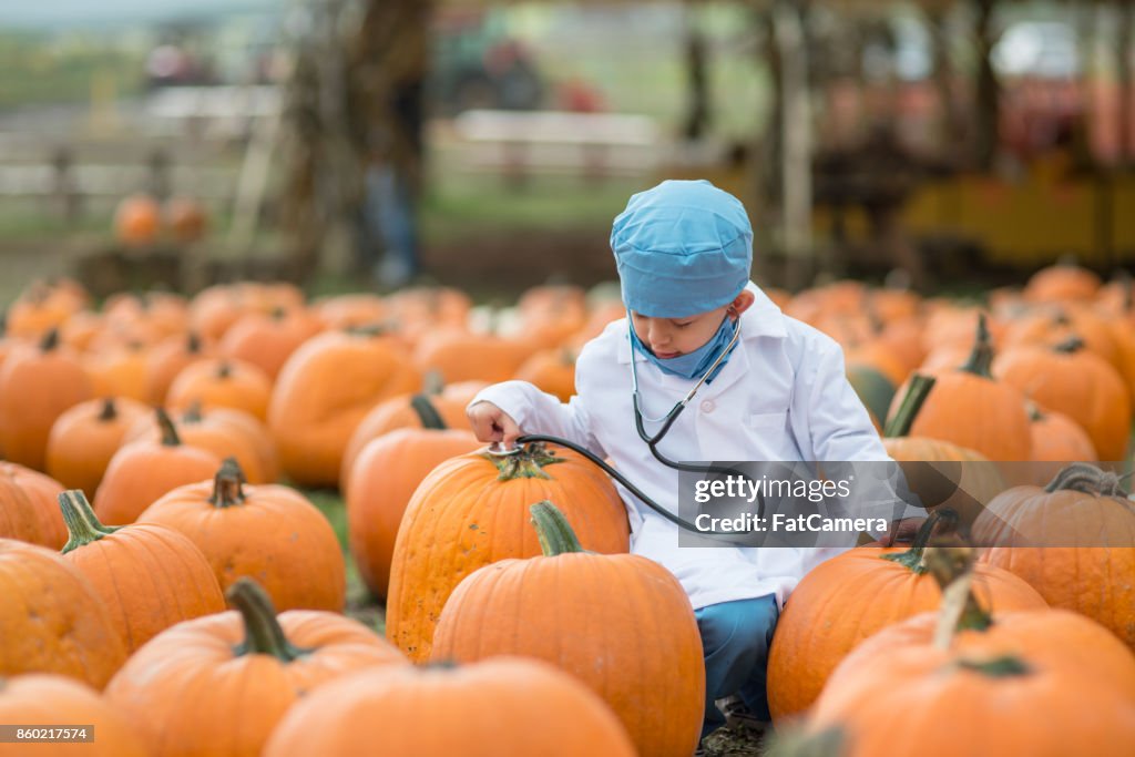Young ethnic boy dressed up like a doctor in pumpkin patch