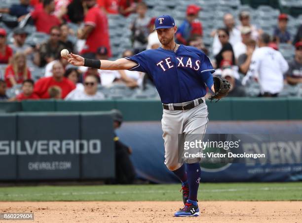 Will Middlebrooks of the Texas Rangers throws to first base during the ninth inning of the MLB game against the Los Angeles Angels of Anaheim at...