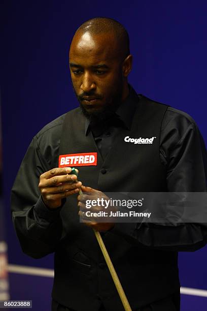 Rory McLeod of England chalks his cue in his first round match against Mark King of England during the Betfred World Snooker Championships at the...