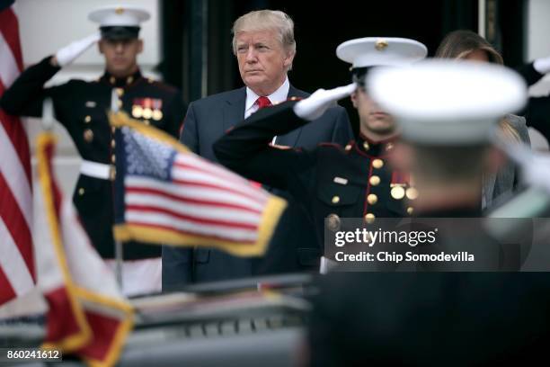 President Donald Trump watches as the vehicle carrying Canadian Prime Minister Justin Trudeau arrives at the White House October 11, 2017 in...