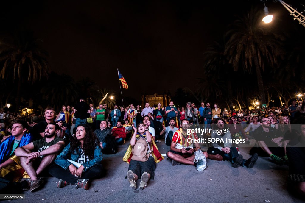 People gather on the floor of the square to follow the...