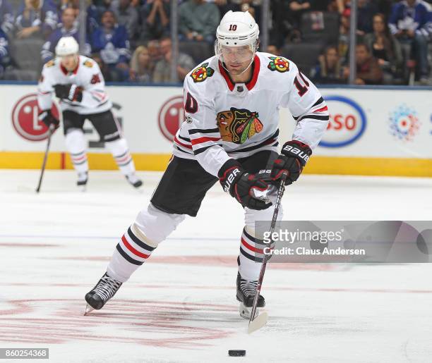 Patrick Sharp of the Chicago Blackhawks picks up a loose puck against the Toronto Maple Leafs in an NHL game at the Air Canada Centre on October 9,...