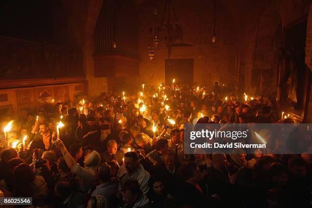 Orthodox Christian pilgrims carry burning candles during the Holy Fire ceremony in the Church of the Holy Sepulchre on April 18, 2009 in Jerusalem's...