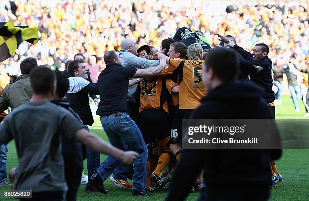 Wolverhampton Wanderers players are mobbed by pitch invaders as they celebrate at the final whistle after winning promotion to the Premier League...