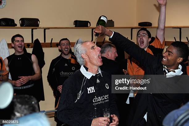 In this handout photo provided by Wolverhampton Wanderers Football Club, Wolverhampton Wanderers manager Mick McCarthy celebrates with champagne with...