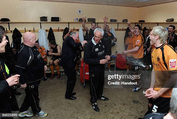 In this handout photo provided by Wolverhampton Wanderers Football Club, Wolverhampton Wanderers manager Mick McCarthy celebrates with champagne with...