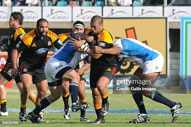 Hika Elliot of the Chiefs is tackled by Wian du Preez and Wayne van Heerden of the Cheetahs during the Super 14 rugby match between Cheetahs and...