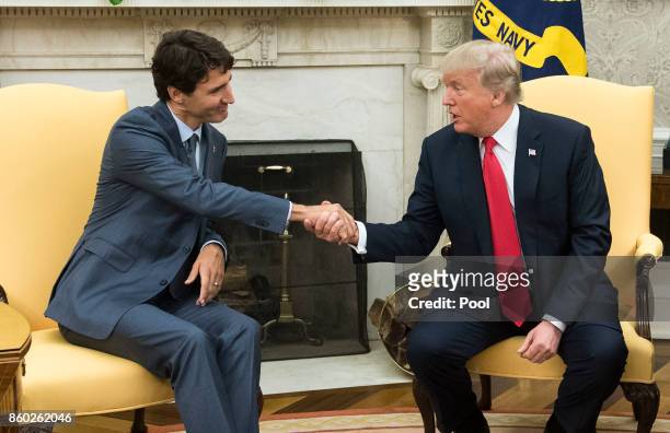 President Donald Trump shakes hands with Canadian Prime Minister Justin Trudeau during a meeting in the Oval Office at the White House on October 11,...