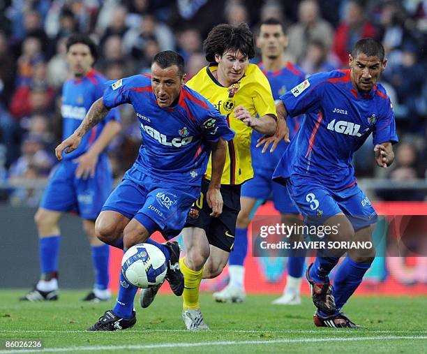 Barcelona Lionel Messi fights for the ball with Getafe's Mario and Daniel Alberto Cata Diaz during a Spanish league football match at Alfonso Perez...