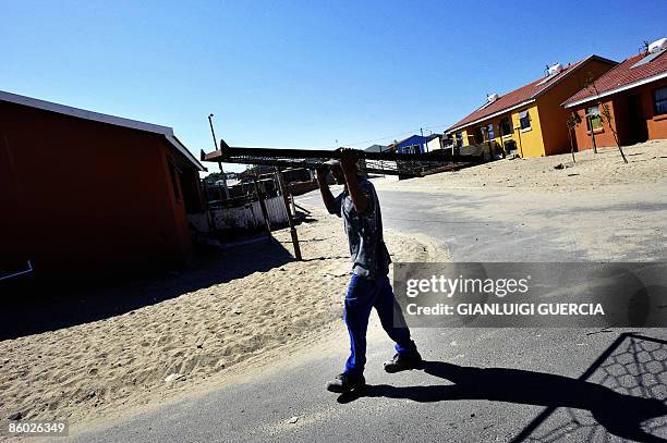 South African man carries an iron net on April 15, 2009 in the streets of Tafelsig township in Mitchells plain on the outskirt of Cape Town, South...